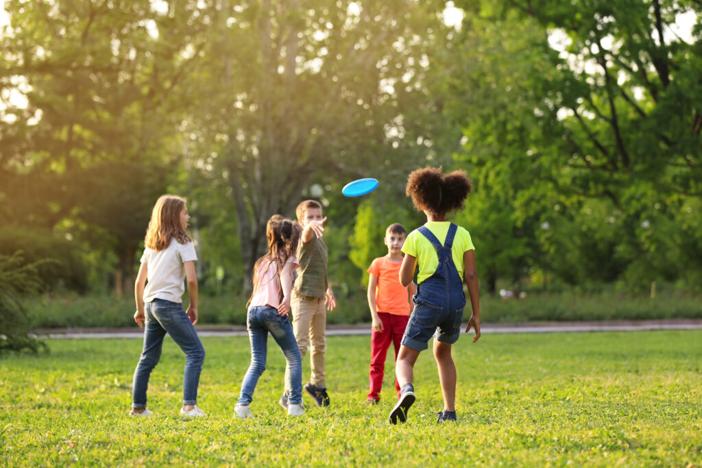 Children playing with frisbee outdoors on sunny day