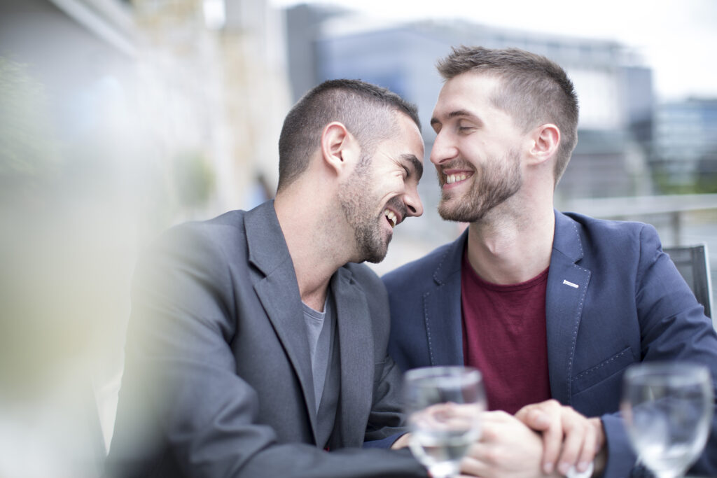 Gay couple sharing an intimate moment at a restaurant