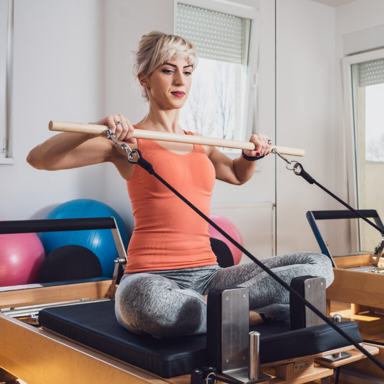 A woman doing Reformer Pilates in Brighton