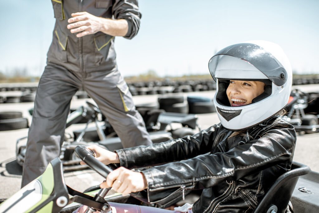 Woman Smiling Driving Go Kart On Racetrack.